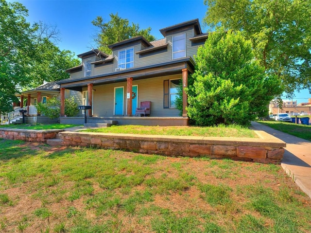 view of front of house with covered porch and a front lawn