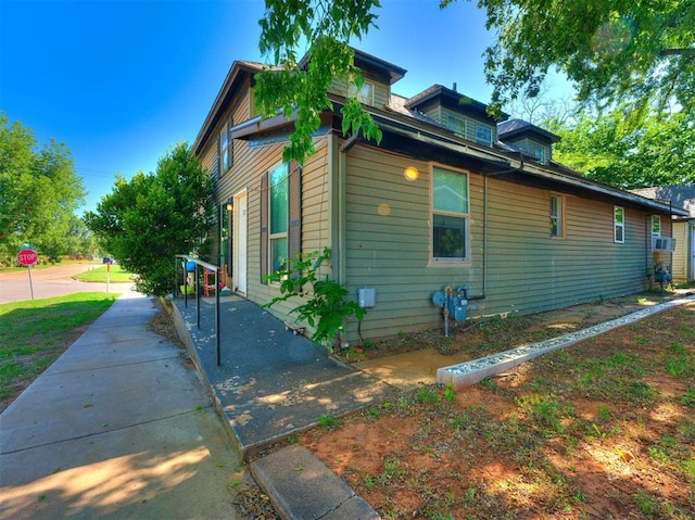 view of side of property featuring cooling unit and a patio area