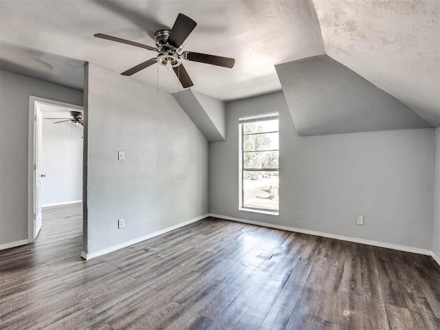 bonus room with ceiling fan, dark wood-type flooring, and vaulted ceiling