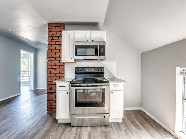 kitchen with white cabinets, hardwood / wood-style floors, stainless steel appliances, and lofted ceiling