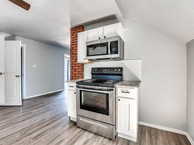 kitchen featuring backsplash, light stone countertops, light hardwood / wood-style floors, white cabinetry, and stainless steel appliances