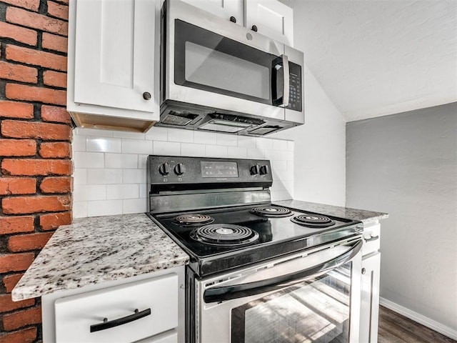 kitchen with backsplash, dark wood-type flooring, white cabinets, light stone countertops, and stainless steel appliances