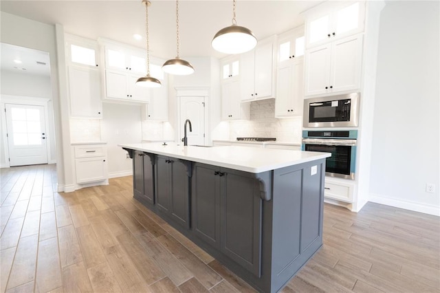 1817 Taines Turn, Norman, OK 73072 - kitchen featuring stainless steel oven, built in microwave, light wood finished floors, white cabinets, and recessed lighting