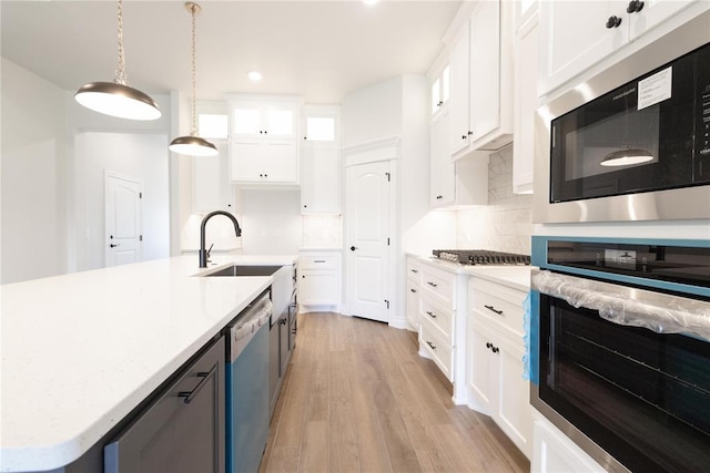 1817 Taines Turn, Norman, OK 73072 - kitchen with stainless steel appliances, a sink, light countertops, white cabinetry, and light wood-type flooring
