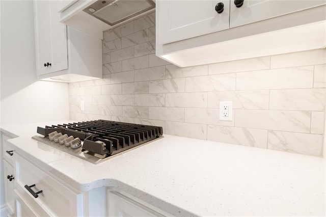 1817 Taines Turn, Norman, OK 73072 - kitchen with stainless steel gas cooktop, under cabinet range hood, white cabinets, backsplash, and light stone counters