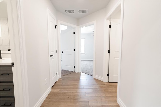 1817 Taines Turn, Norman, OK 73072 - hallway with light wood-style flooring and baseboards