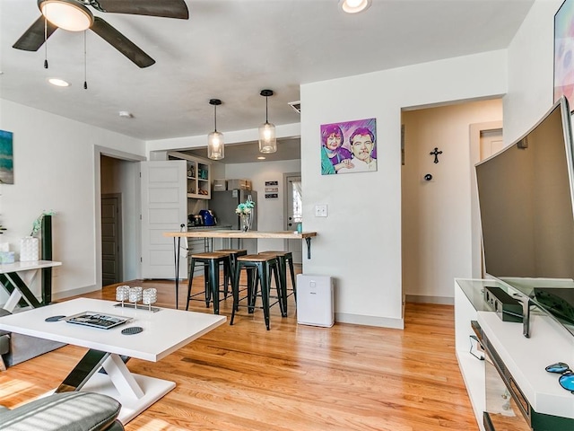 home office with ceiling fan and light hardwood / wood-style floors