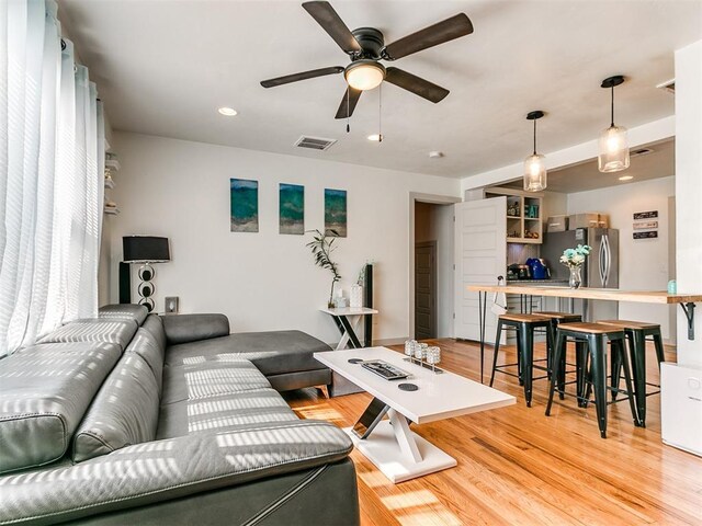 living room with light hardwood / wood-style flooring and ceiling fan