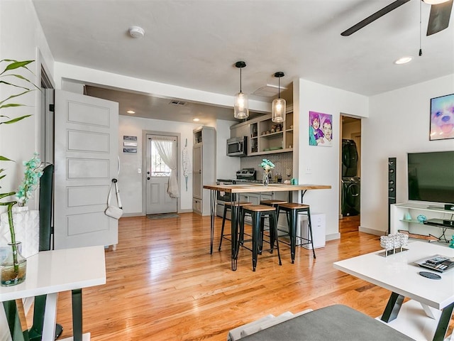 living room featuring ceiling fan and light wood-type flooring