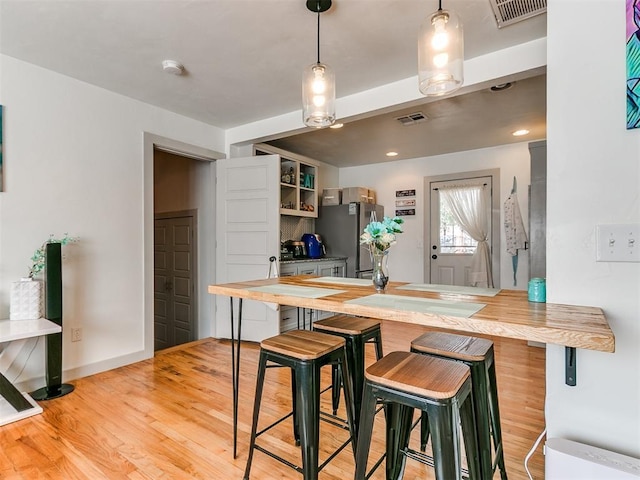 kitchen featuring kitchen peninsula, stainless steel fridge, and a kitchen breakfast bar