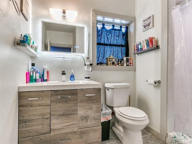 bathroom featuring tile patterned flooring, vanity, curtained shower, and toilet