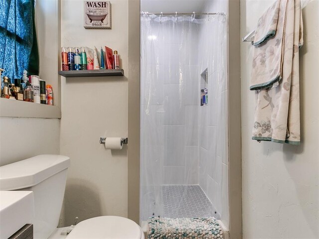 bathroom featuring curtained shower and toilet