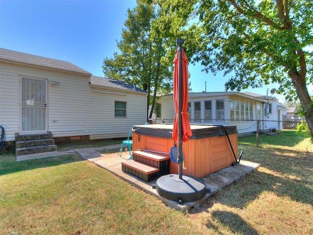 rear view of property featuring a lawn and a hot tub