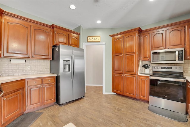 kitchen with light hardwood / wood-style floors, appliances with stainless steel finishes, and tasteful backsplash