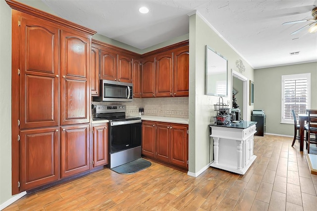 kitchen with decorative backsplash, light hardwood / wood-style flooring, ceiling fan, and appliances with stainless steel finishes