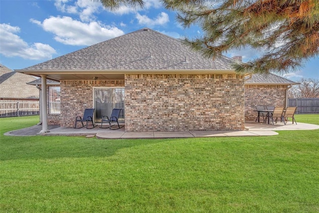 rear view of house with a patio and a lawn