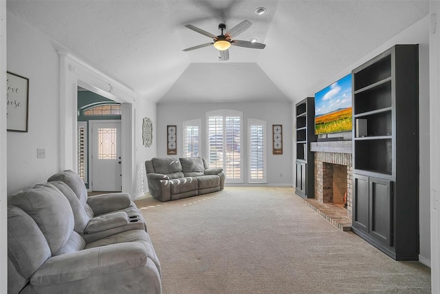 living room featuring built in shelves, ceiling fan, a brick fireplace, light colored carpet, and lofted ceiling