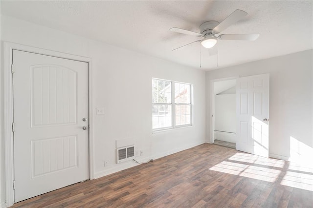 unfurnished room featuring a textured ceiling, ceiling fan, and dark wood-type flooring