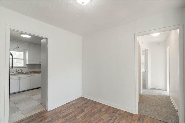 spare room with sink and light wood-type flooring