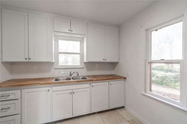 kitchen featuring wood counters, decorative backsplash, a wealth of natural light, and sink