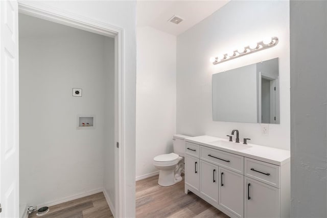 bathroom featuring toilet, vanity, and hardwood / wood-style flooring