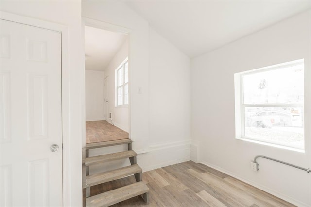 stairway with hardwood / wood-style floors and lofted ceiling