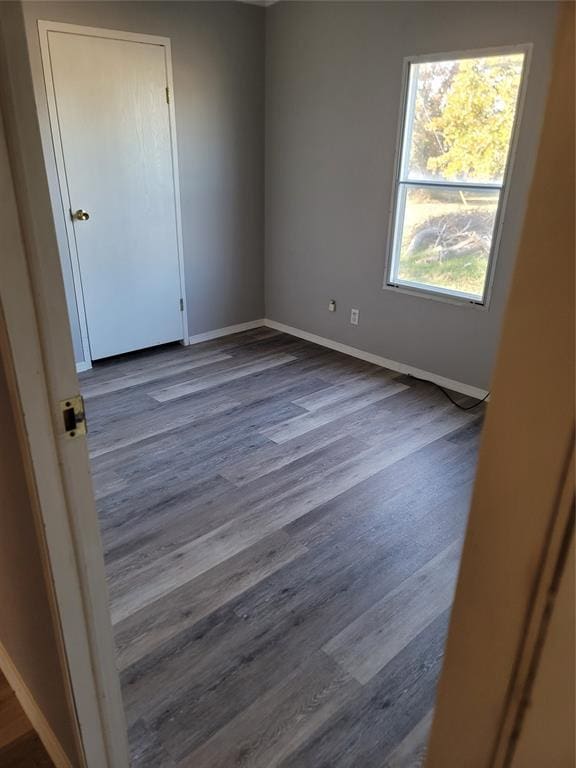 unfurnished room featuring dark wood-type flooring