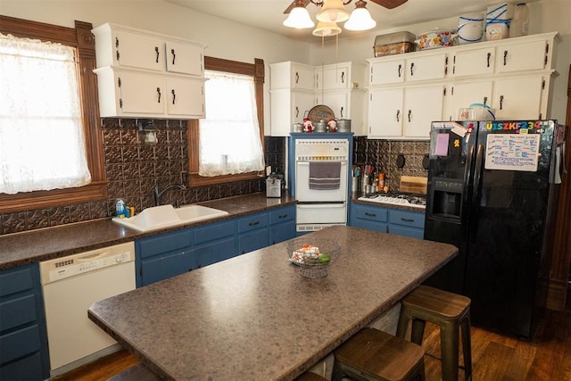 kitchen with white cabinets, white appliances, sink, and blue cabinets