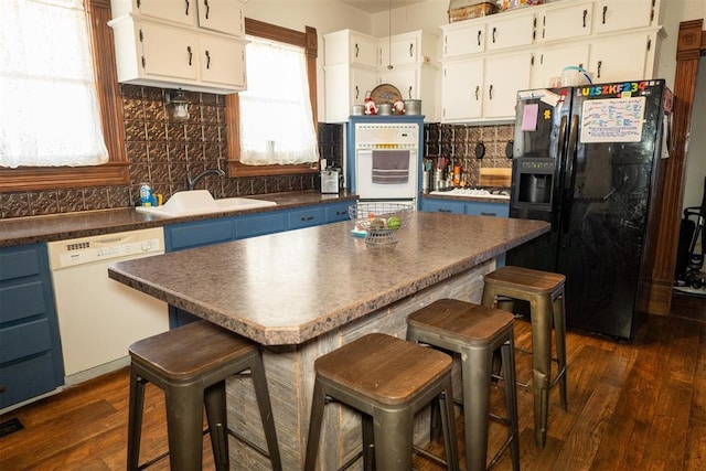 kitchen featuring dark hardwood / wood-style floors, white cabinetry, white appliances, and sink