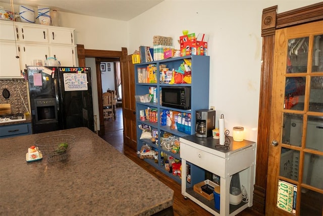 kitchen with dark wood-type flooring, white cabinets, and black appliances