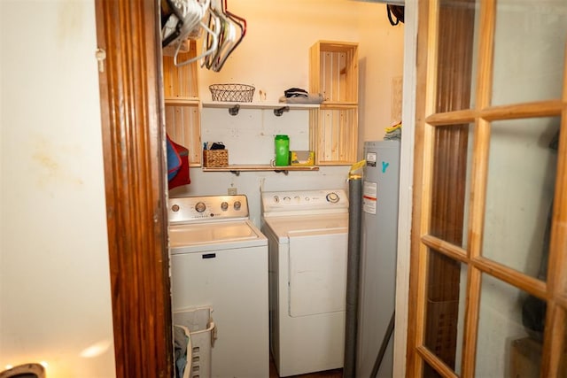 clothes washing area with washing machine and dryer and water heater