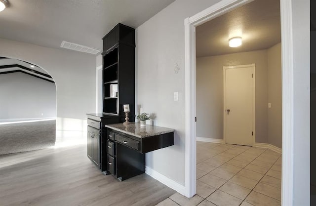 kitchen featuring light tile patterned floors and light stone counters