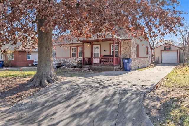 single story home with covered porch, a garage, and an outdoor structure