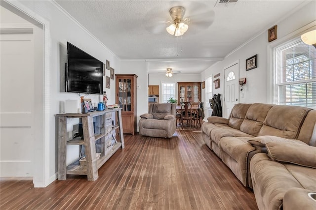 living room with hardwood / wood-style floors, a textured ceiling, ceiling fan, and ornamental molding