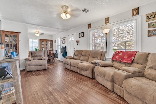 living room featuring hardwood / wood-style floors, ceiling fan, a textured ceiling, and a wealth of natural light