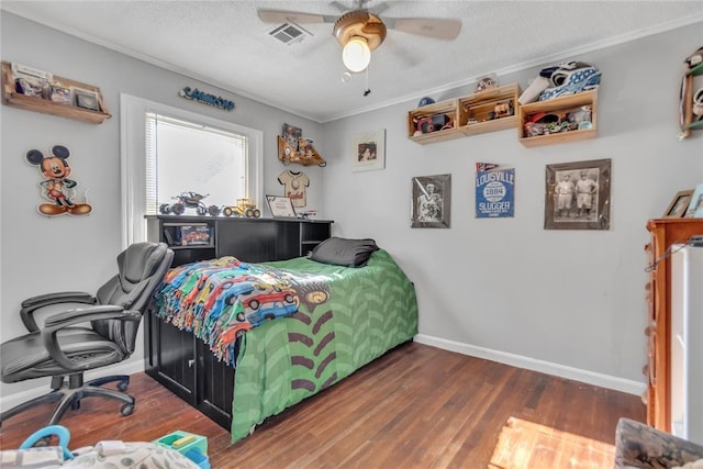 bedroom with a textured ceiling, ceiling fan, dark hardwood / wood-style floors, and ornamental molding