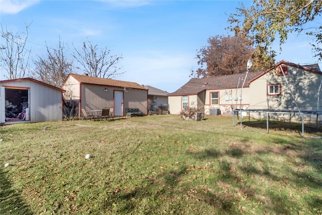 view of yard with central AC unit, a storage unit, and a trampoline