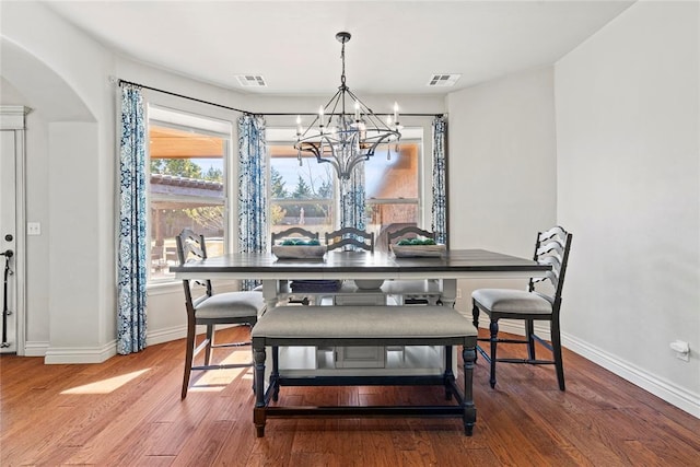 dining room featuring hardwood / wood-style flooring and an inviting chandelier