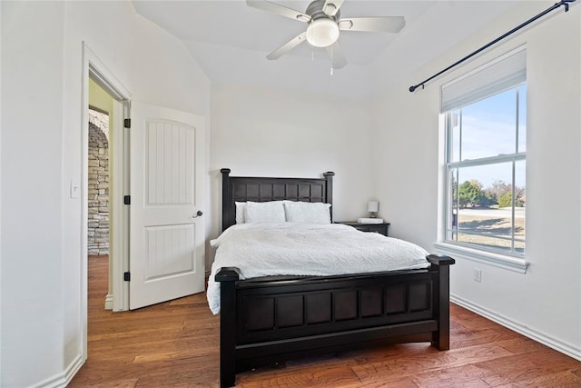 bedroom featuring ceiling fan, hardwood / wood-style floors, and lofted ceiling