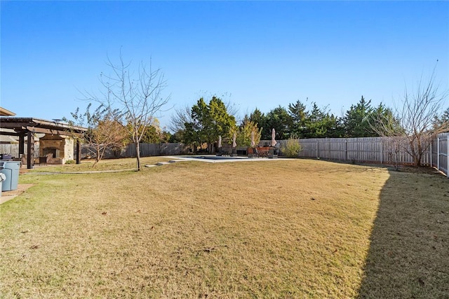 view of yard with an outdoor fireplace