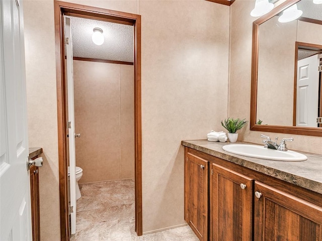 bathroom featuring vanity, ornamental molding, a textured ceiling, and toilet