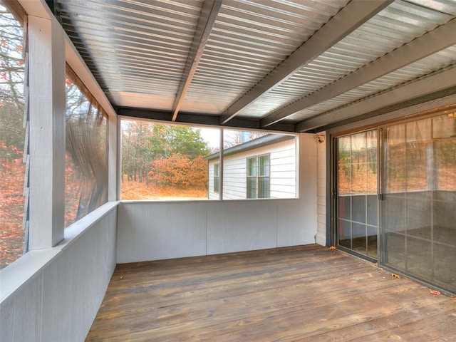 unfurnished sunroom with beam ceiling and plenty of natural light