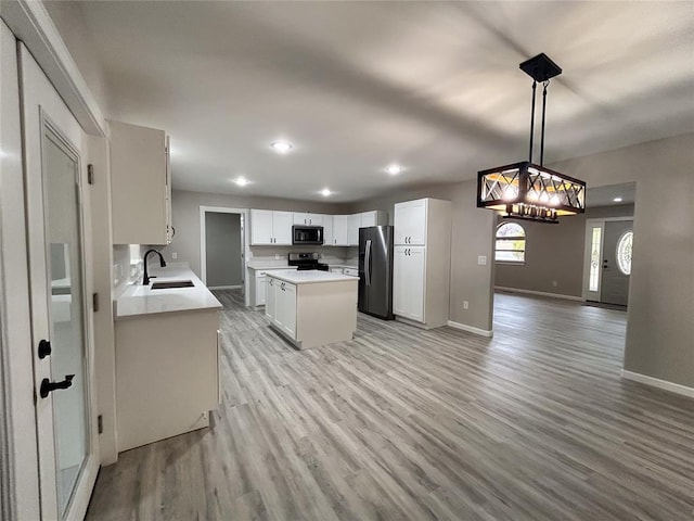 kitchen featuring white cabinetry, sink, light wood-type flooring, and appliances with stainless steel finishes