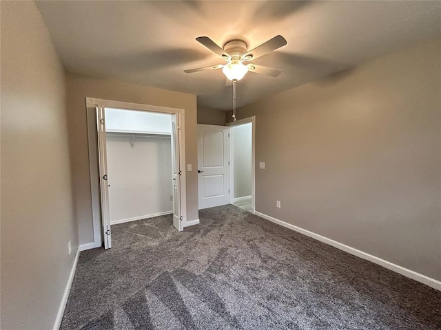 unfurnished bedroom with a closet, dark carpet, and ceiling fan