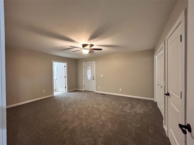 interior space featuring dark carpet and ceiling fan