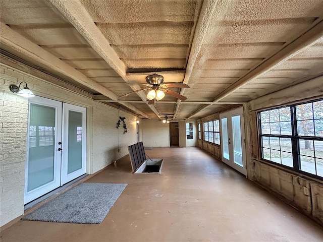 unfurnished sunroom with ceiling fan and french doors