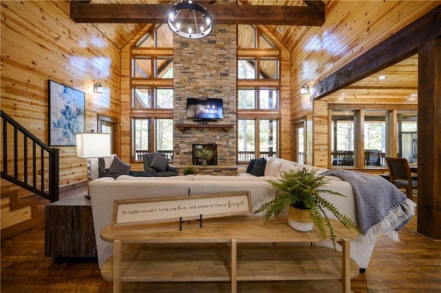 living room with beamed ceiling, a healthy amount of sunlight, and high vaulted ceiling