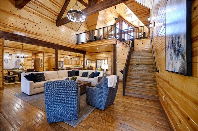 living room with beam ceiling, high vaulted ceiling, wooden walls, and hardwood / wood-style floors