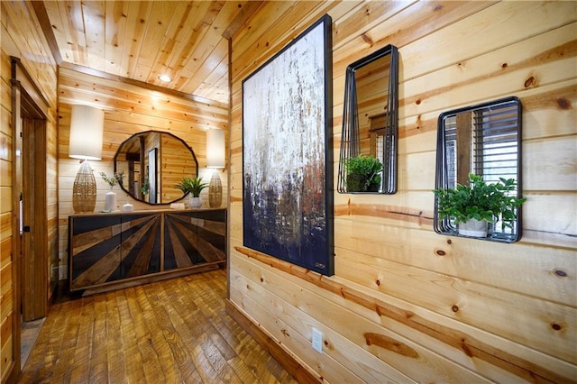 interior space with hardwood / wood-style floors, wood walls, and wooden ceiling