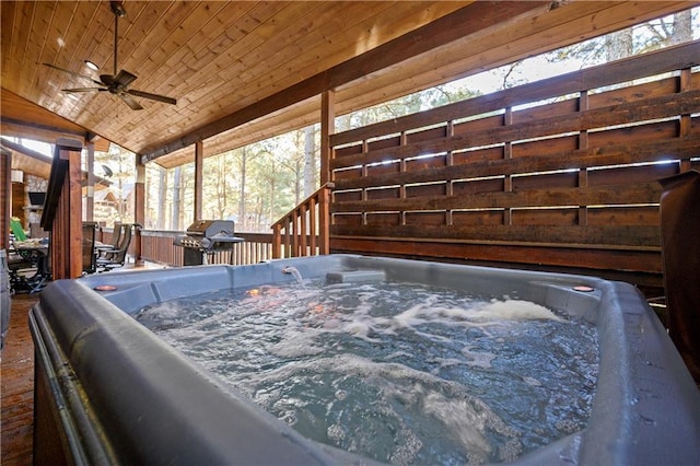 wooden deck with ceiling fan, grilling area, and a hot tub